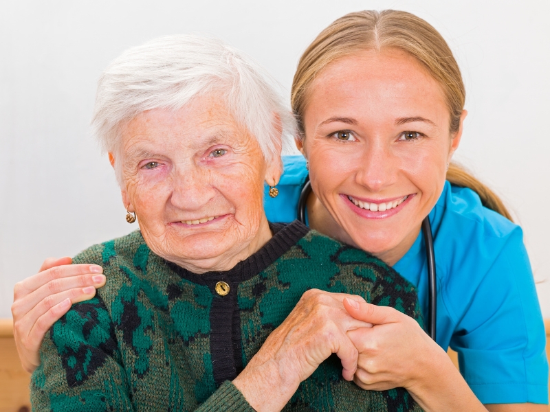 Caregiver assisting elderly woman with personal care and support at home